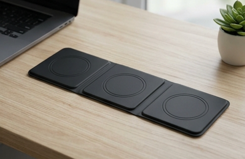 Coilgrove 3-in-1 wireless charging stand on a wooden desk beside a laptop